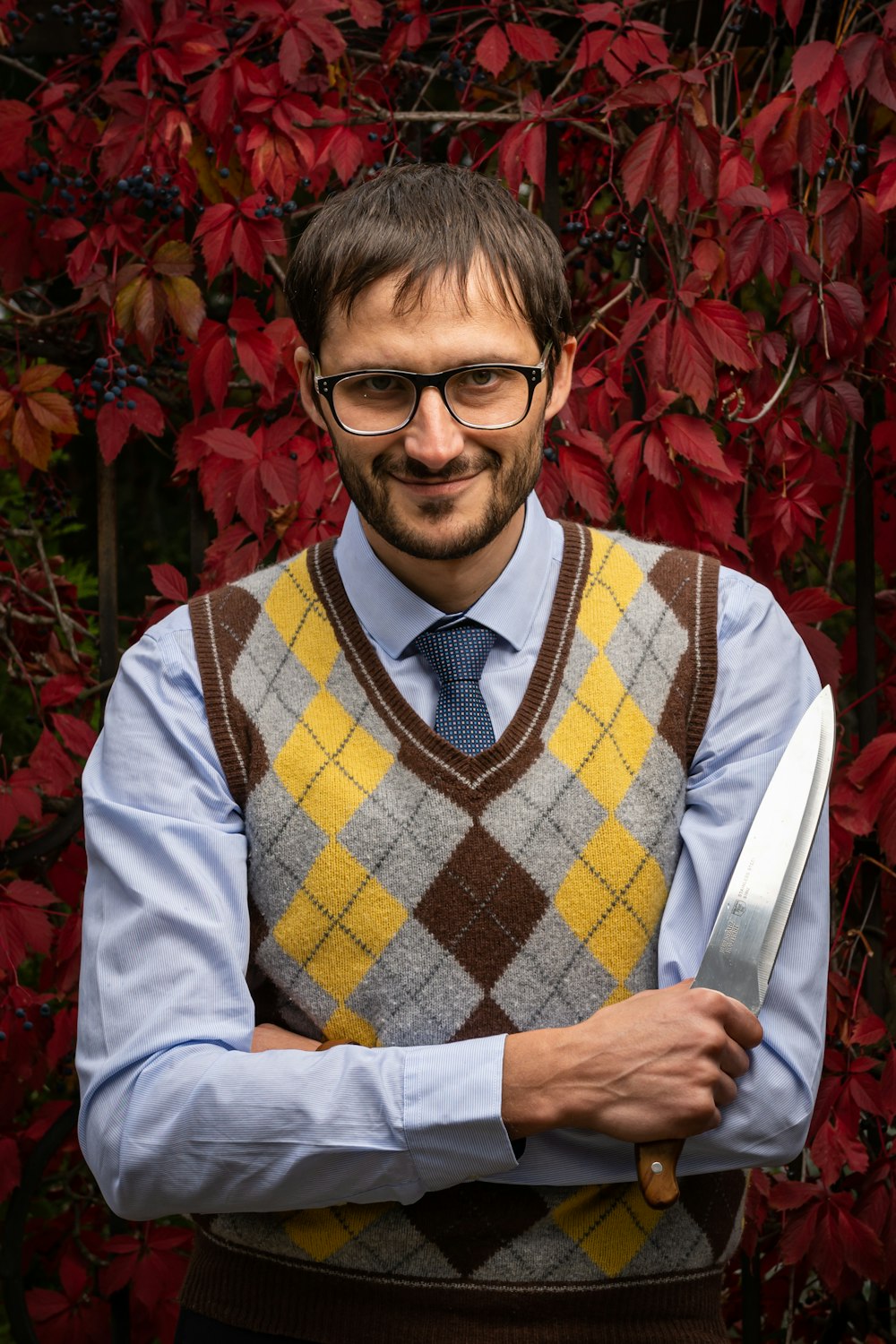 man wearing light-blue collared button-up long-sleeved shirt and eyeglasses standing and smiling