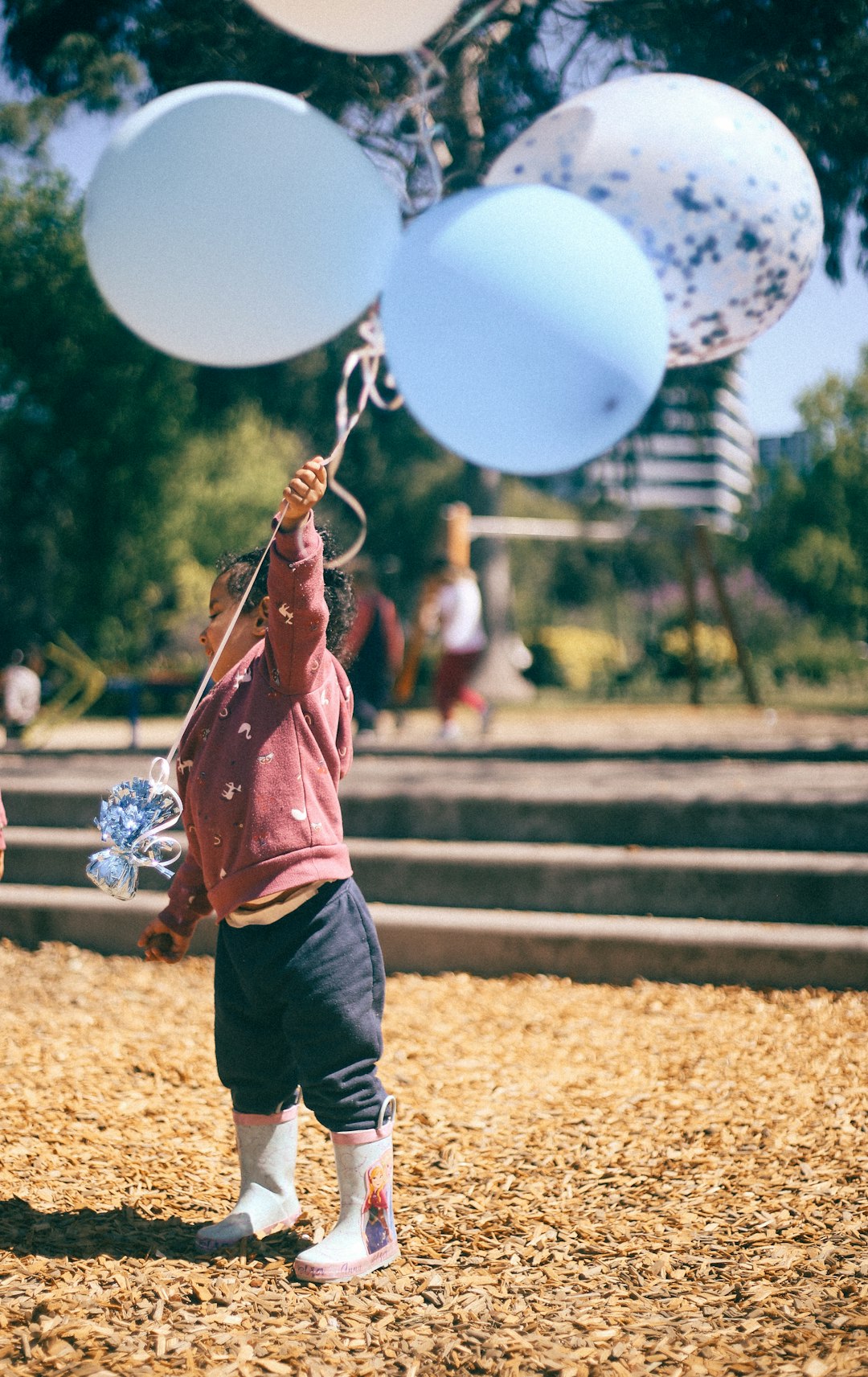 boy holding balloons at daytime