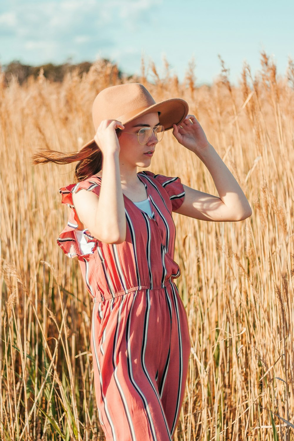 Mujer con vestido rojo y negro de pie cerca del campo