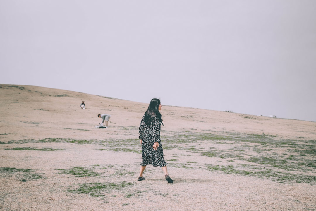 woman walking near people at the field during day