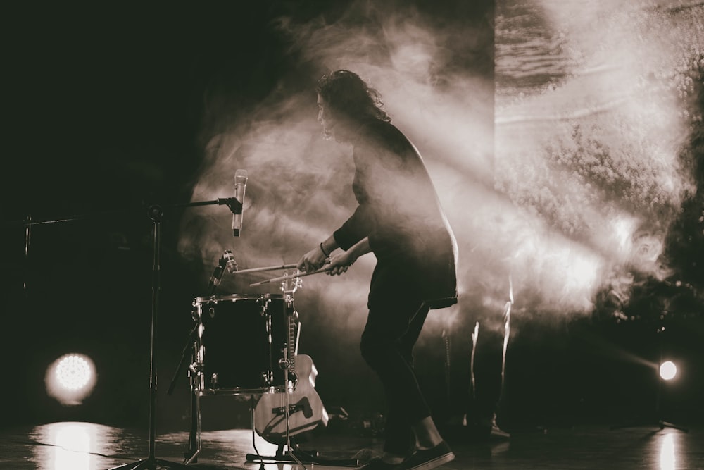 grayscale photography of person playing the drums