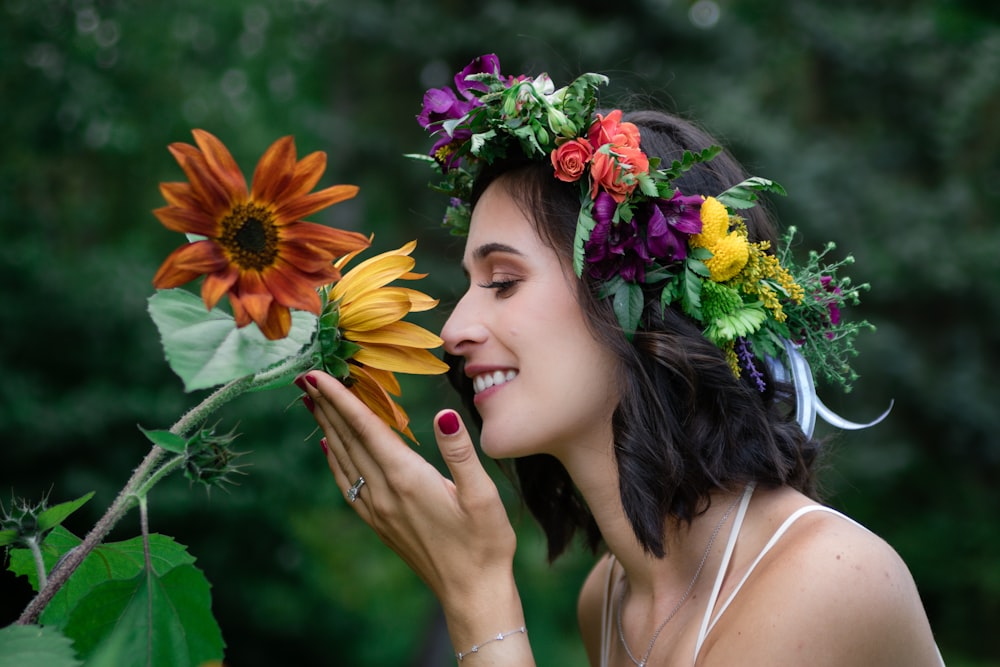 selective focus photography of woman smelling flower