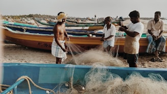 Fishermen repairing their nets by the riverbank during early morning