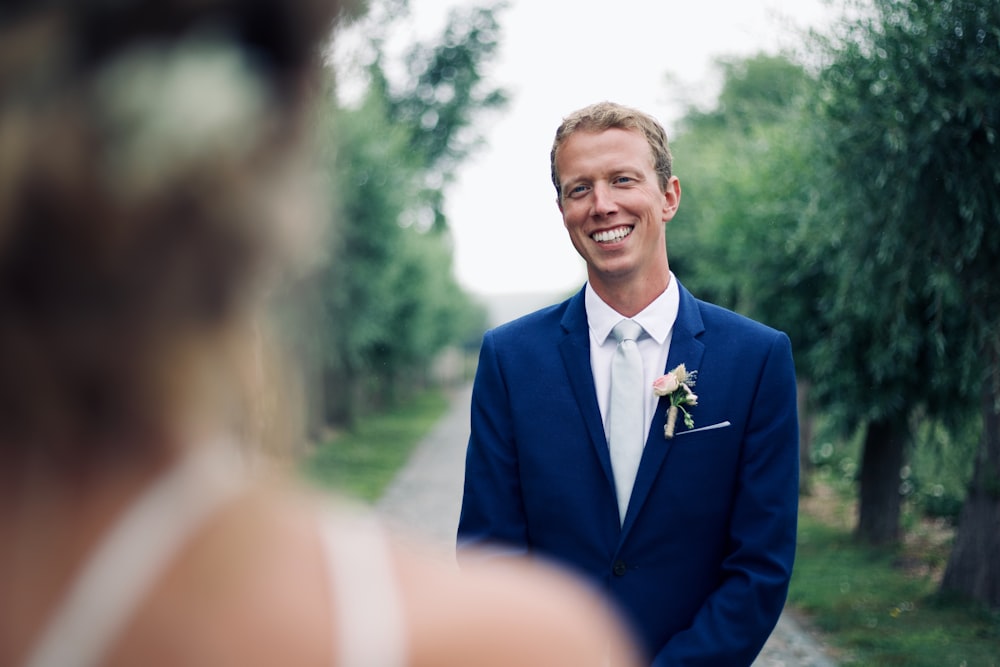 shallow focus photo of man in blue suit jacket