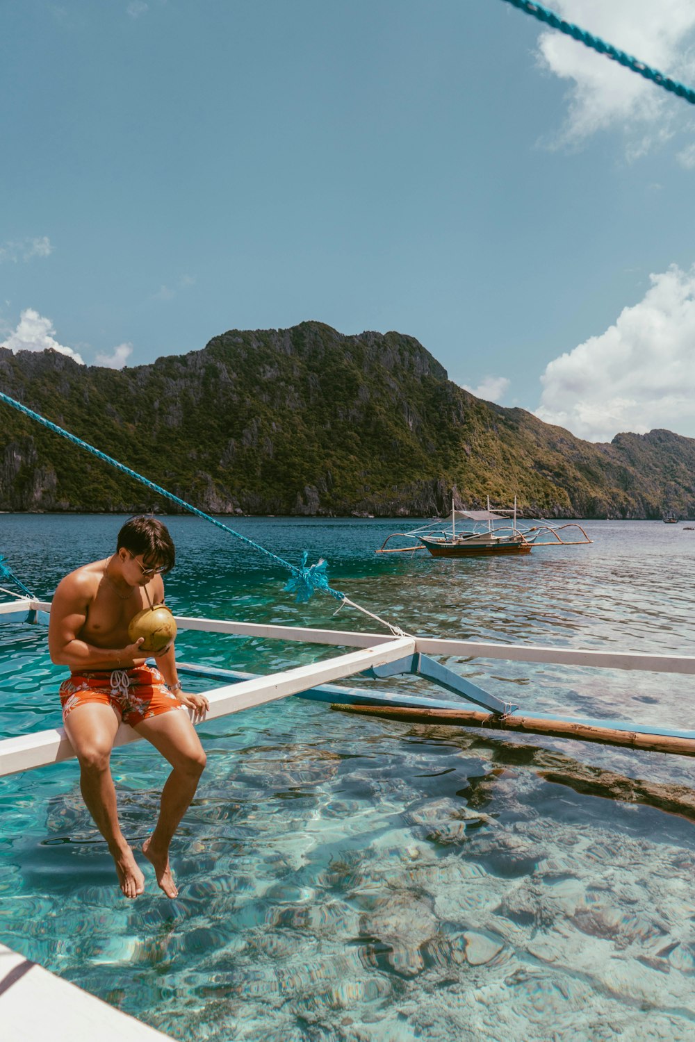 man drinking coconut on the boat