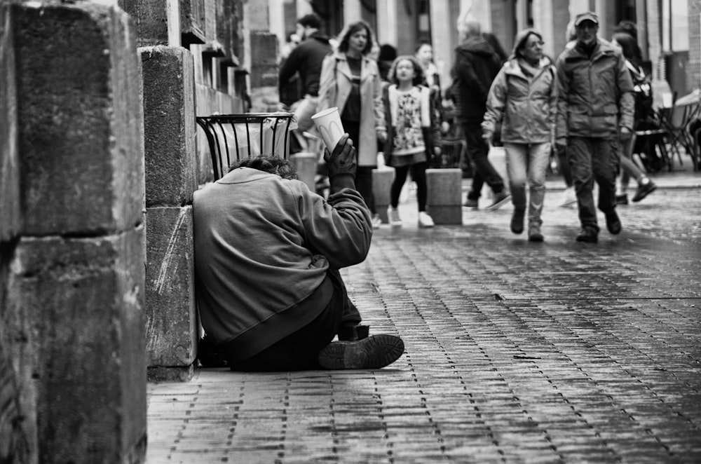 a man sitting on a bench next to a building