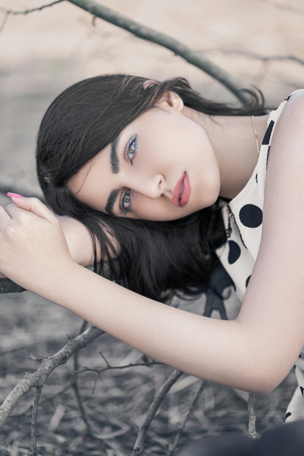 woman wearing white and black polka-dot sleeveless top