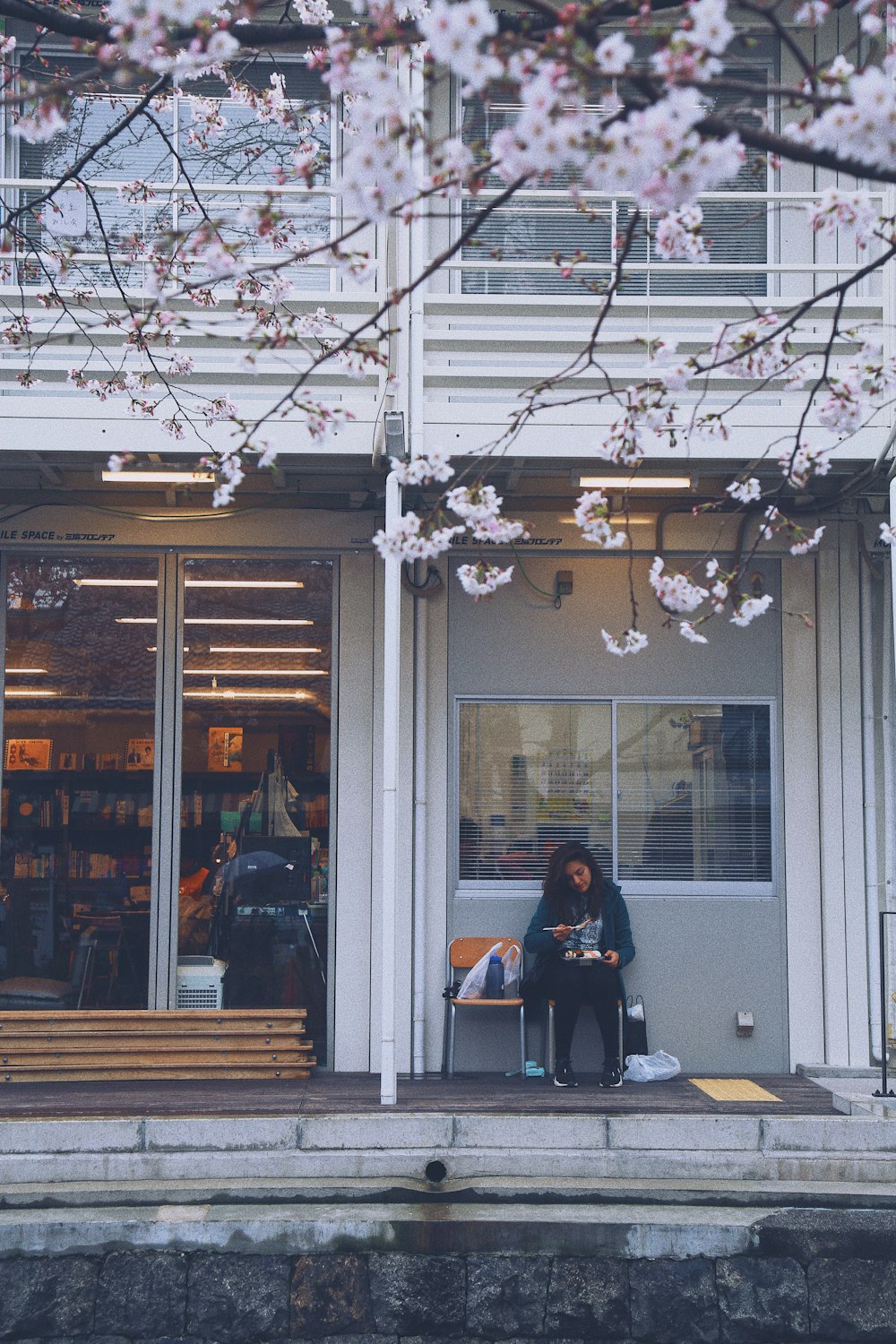 woman sitting on chair beside street