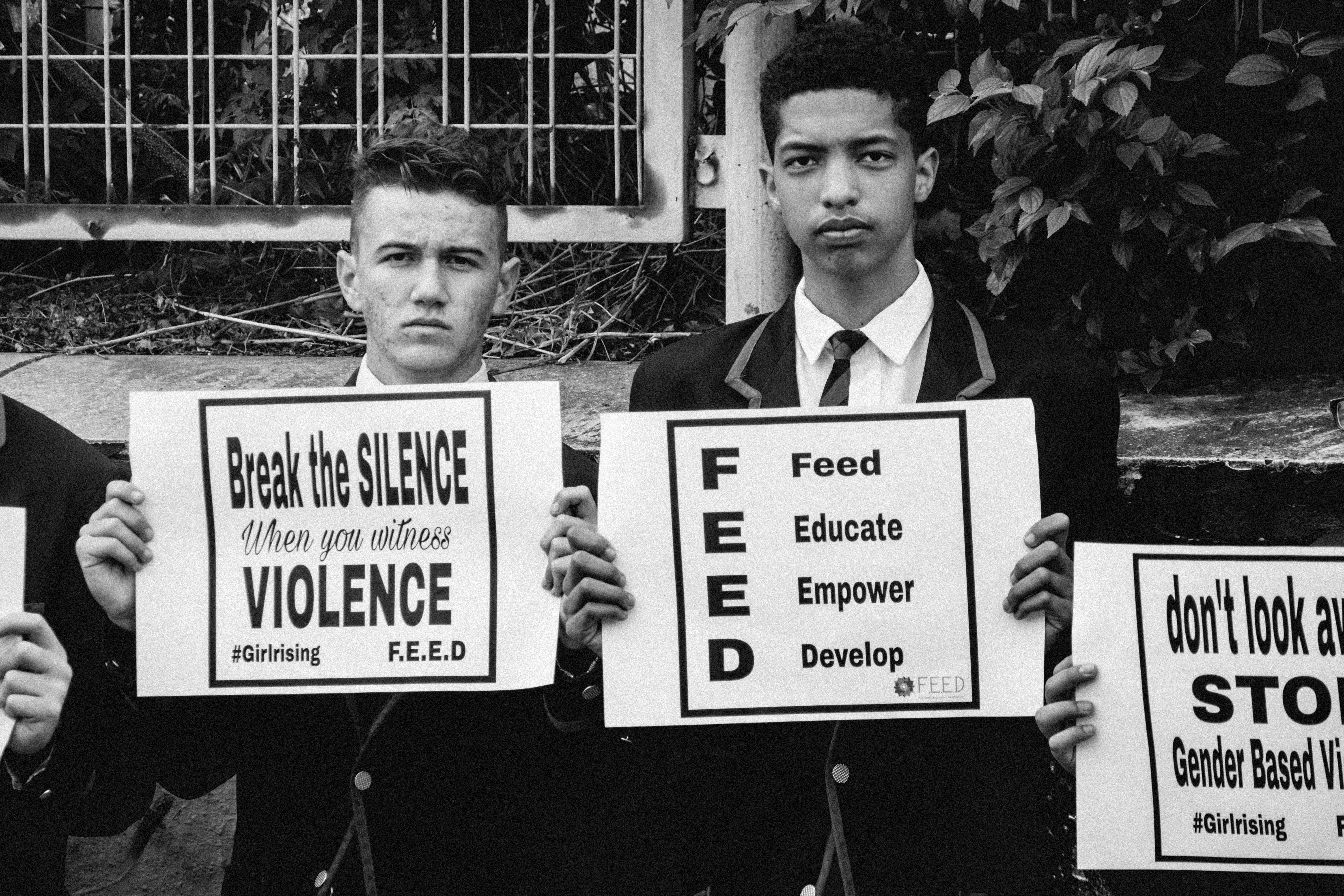 grayscale photography of two men holding banners, Gender-Based Violence in South Africa