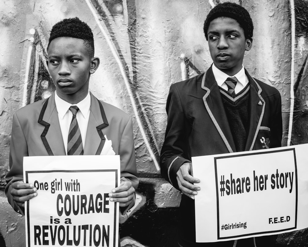 grayscale photography of two men holding banners