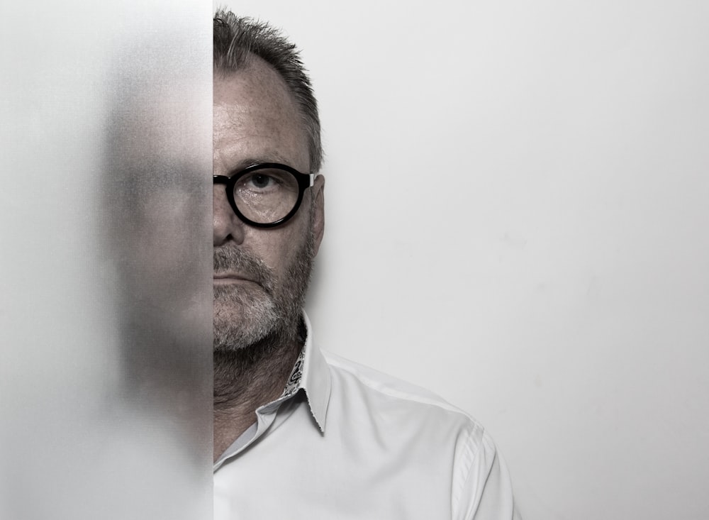 man in black-framed eyeglasses and white button-up shirt