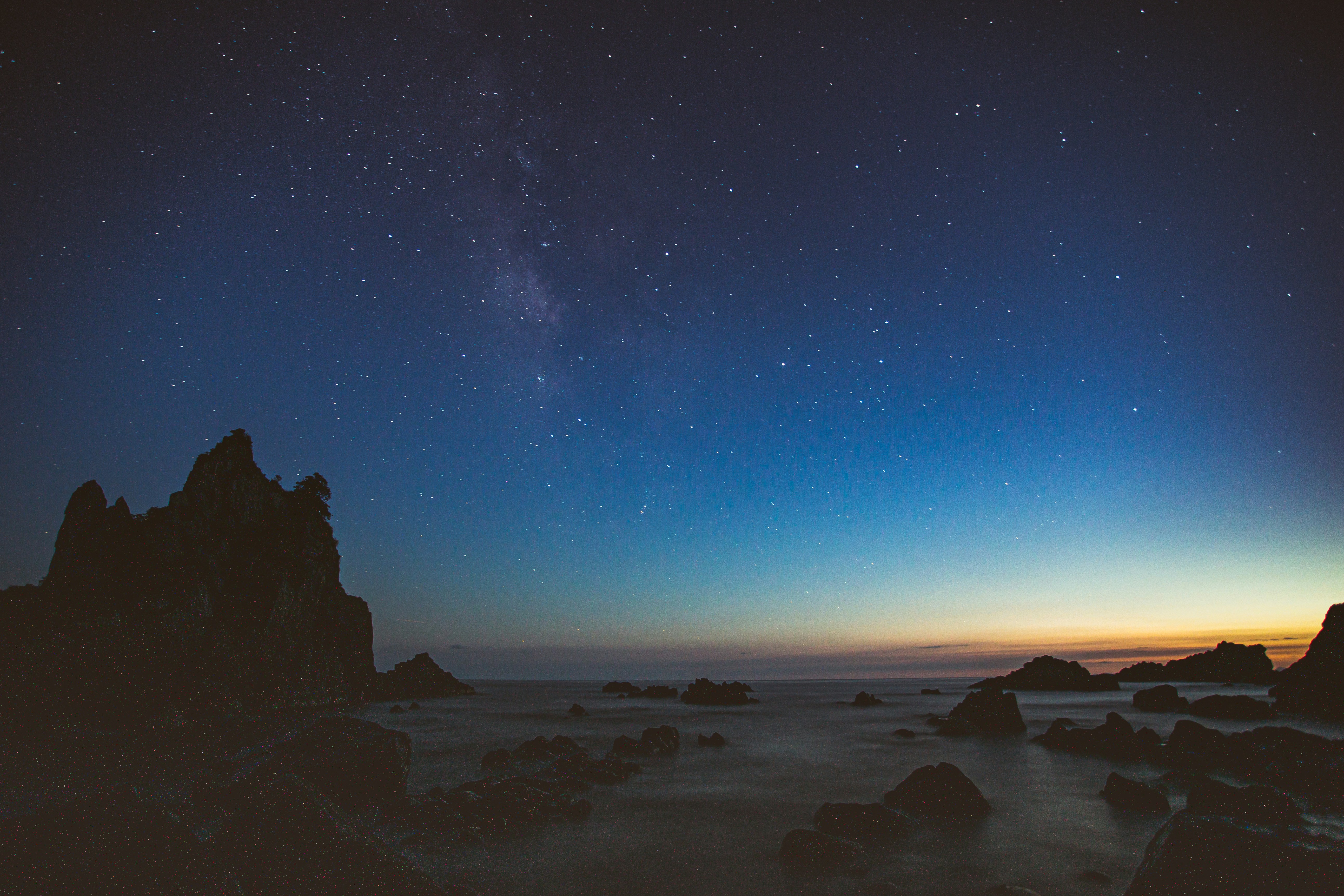 Boulders on body of water during golden hour photo – Free Blue Image on ...