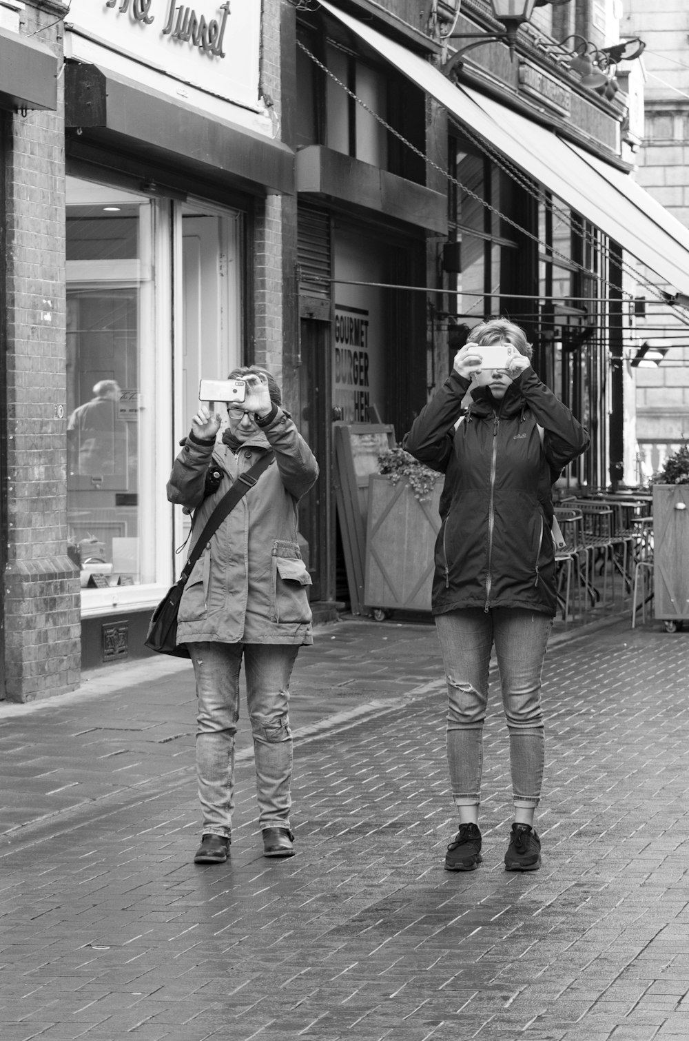 grayscale photo of man and woman taking photo
