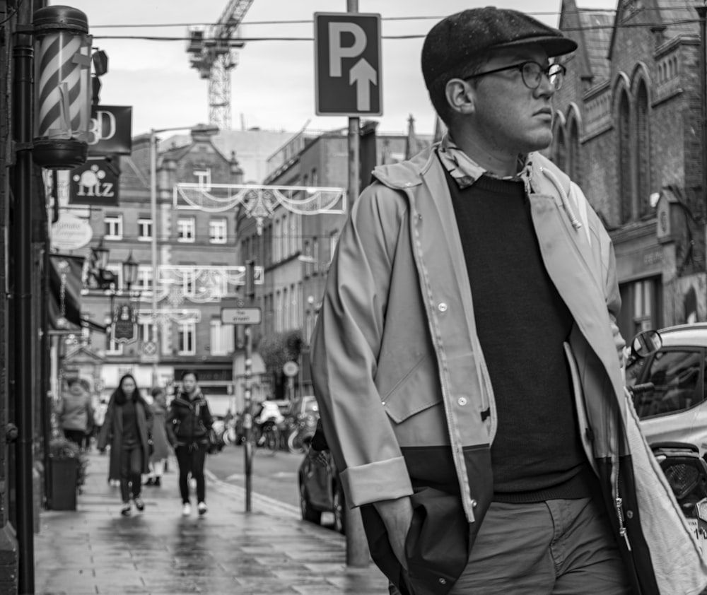 grayscale of man walking onsidewalk