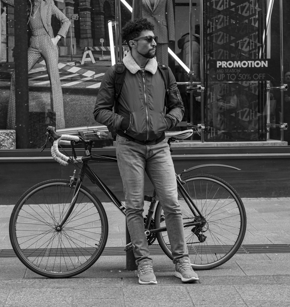 man leaning on bollard near bicycle