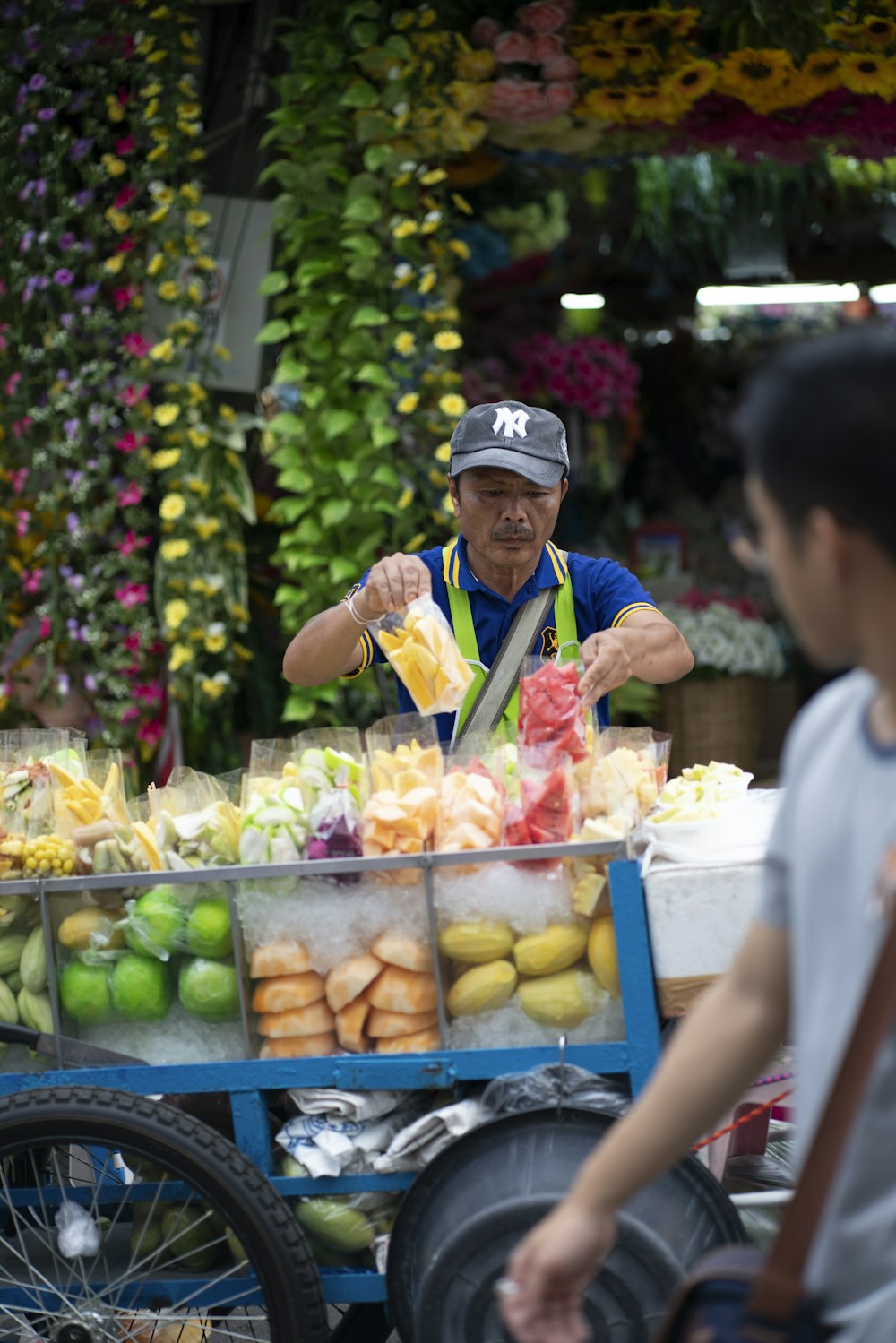 man standing beside food cart