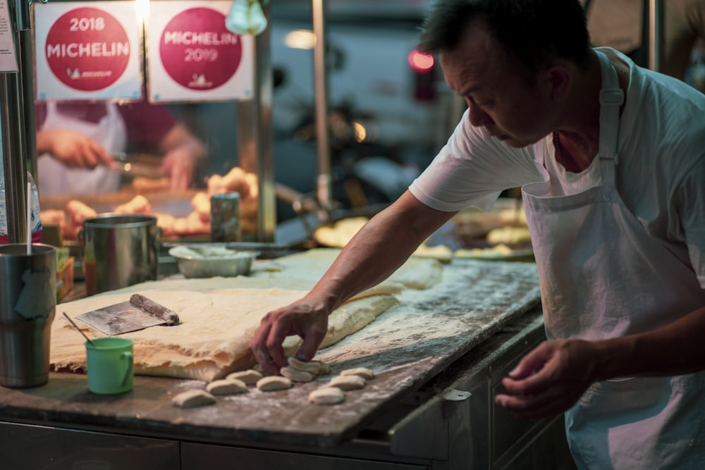 man in white shirt doing dough