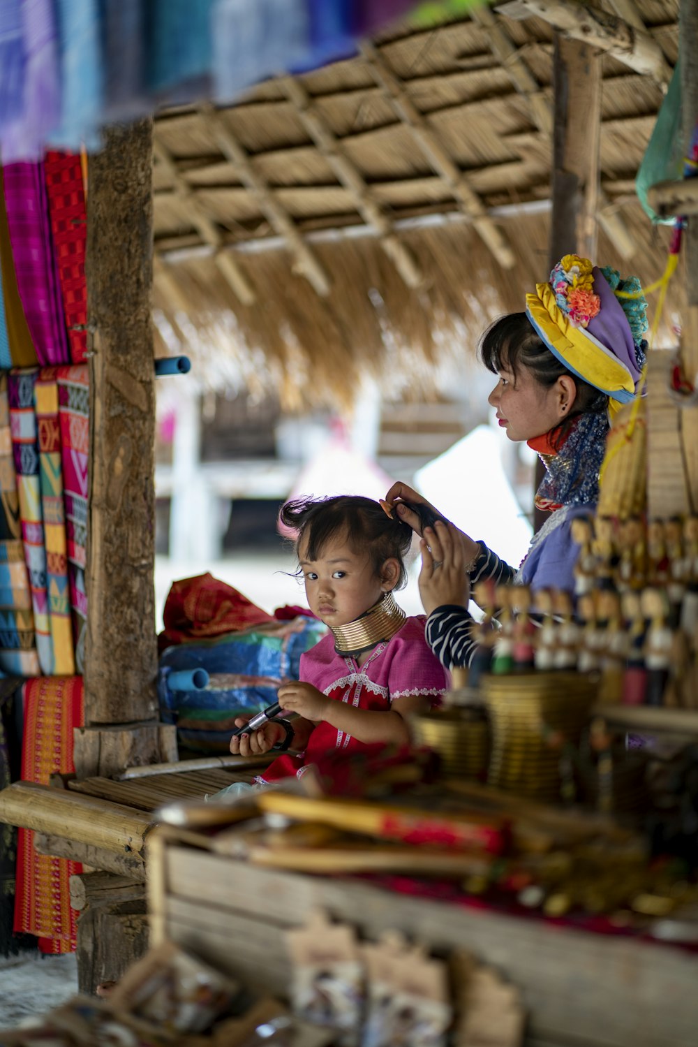 child and woman under hut