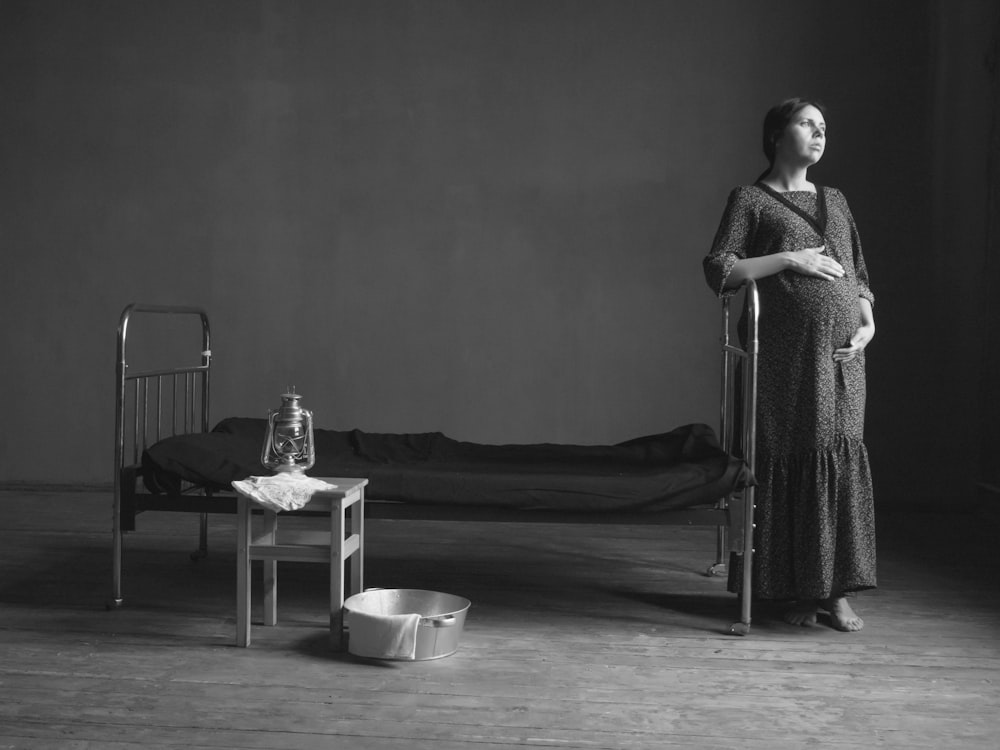 pregnant woman standing near the bed