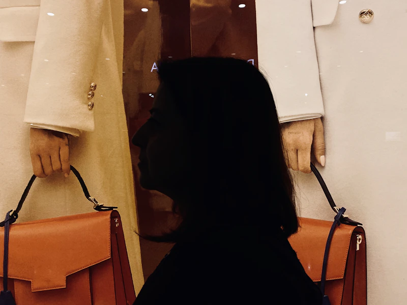 a woman standing next to another woman holding a purse