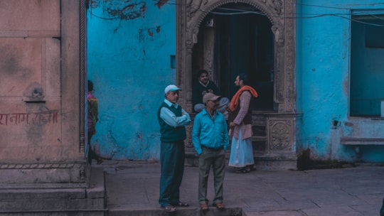 group of people standing in front of blue building in Mathura India