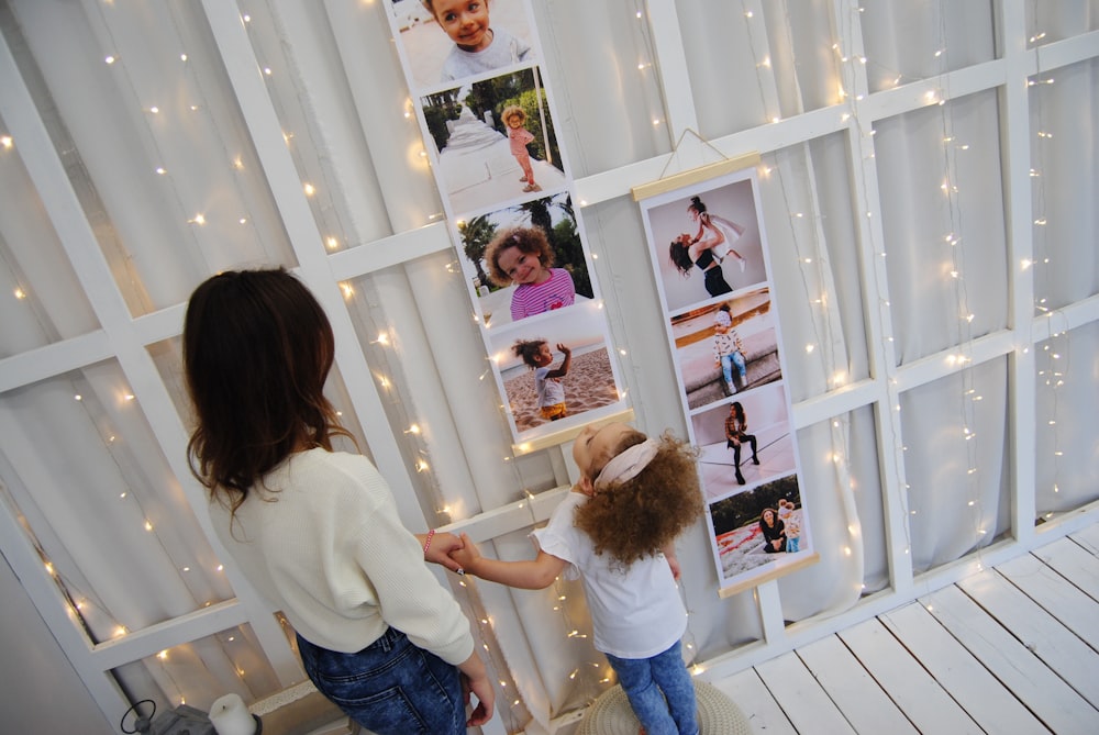 woman and girl looking pictures on wall