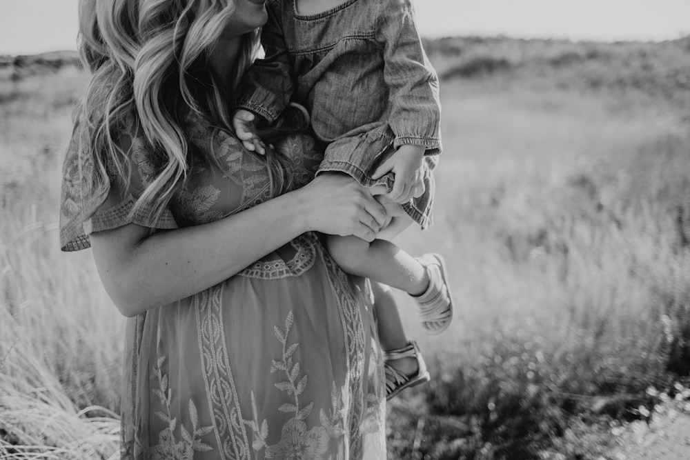 mujer cargando niño pequeño