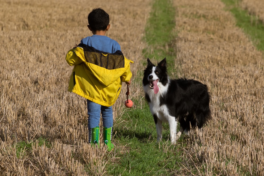 boy walking with black dog