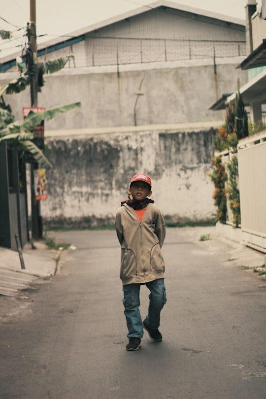 boy walking on street during daytime in Malang Indonesia