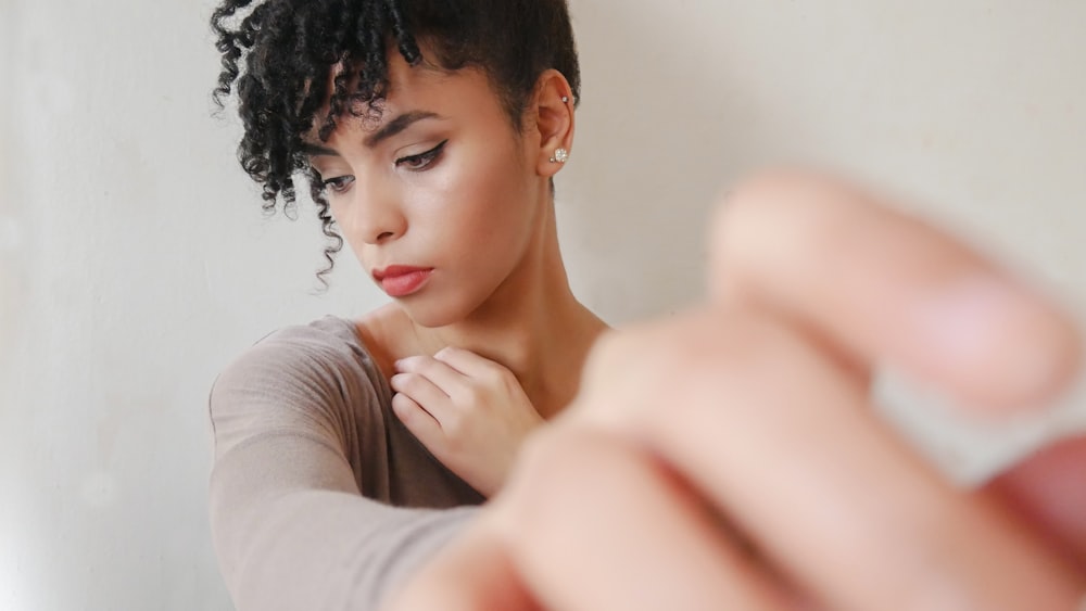 woman sitting near white wall