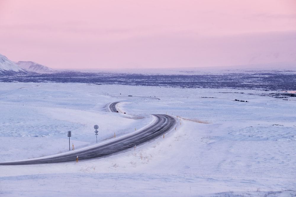 a winding road in the middle of a snowy landscape