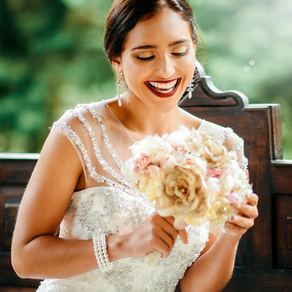 selective focus photo of woman holding bouquet of flower
