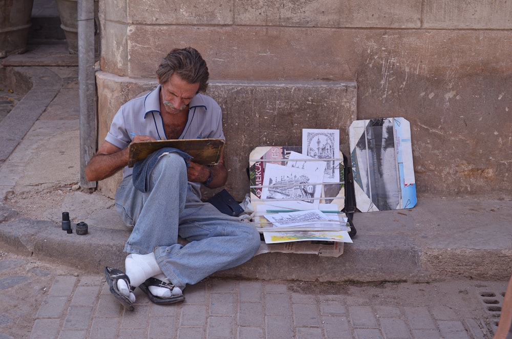 man sitting on sidewalk