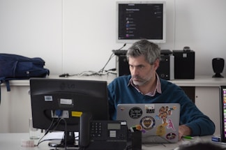 Photo of a confident disabled veteran working at a desk with a laptop and government contract documents.