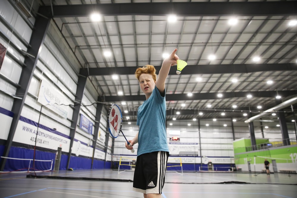 boy about to serve a badminton shuttle cock