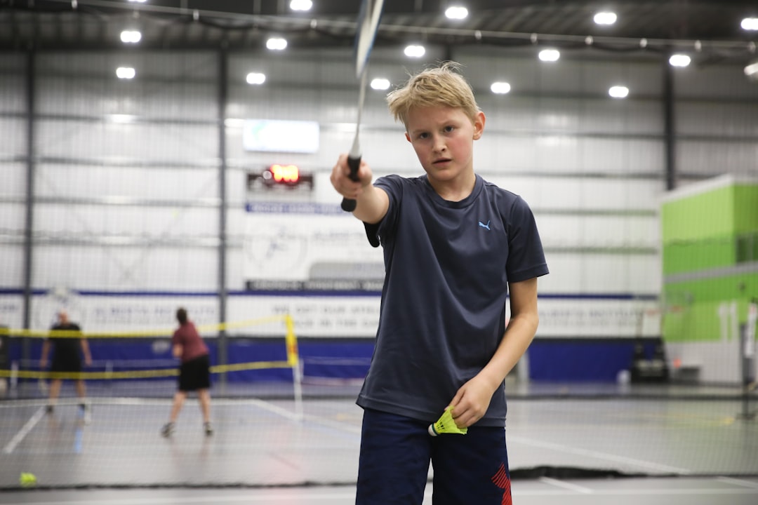 boy pointing a badminton racket in front