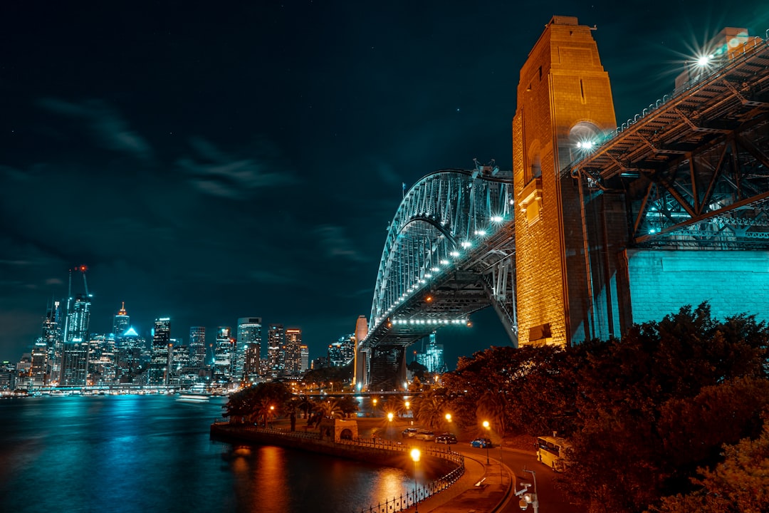 low-angle photograph of concrete and metal bridge at nightr, A night view of Sydney Harbour Bridge and city skyline from north shore of Sydney Harbour