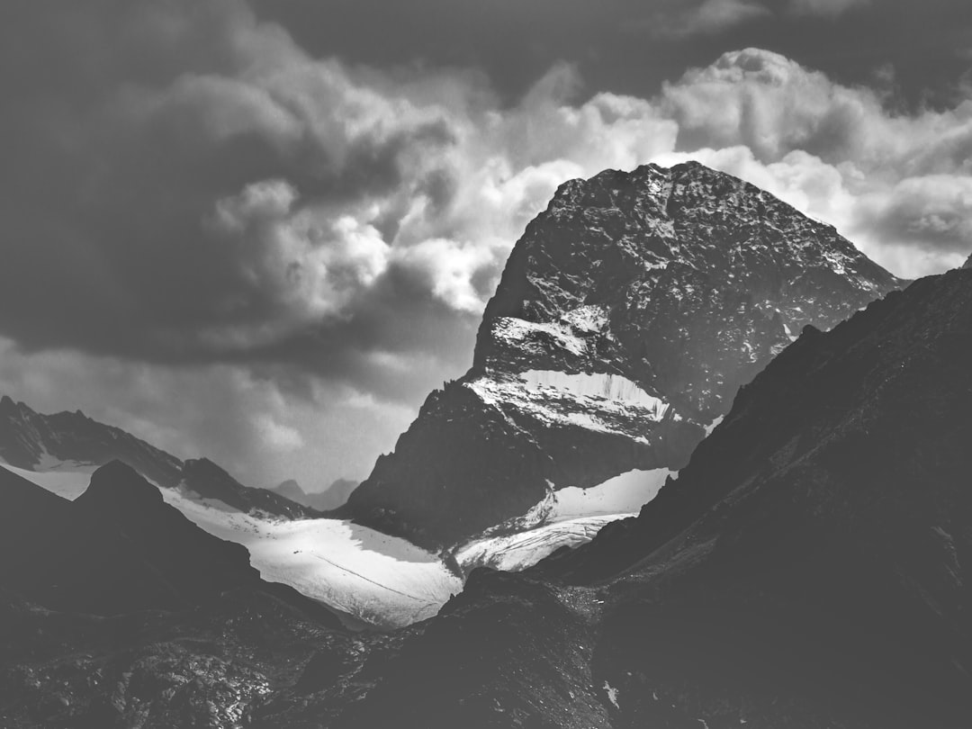 grayscale photo of mountains under cloudy sky