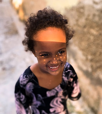 A child smiling confidently after a dental checkup with colorful walls in the background.