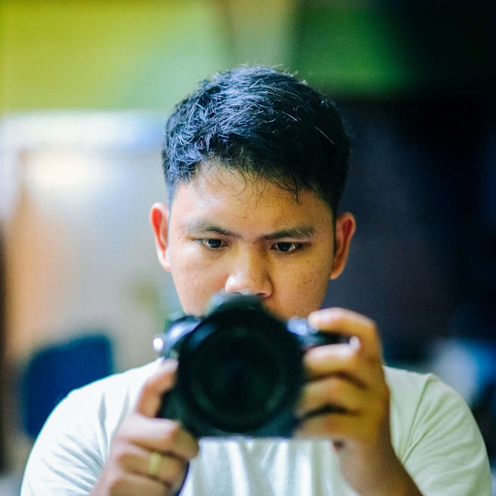 selective focus photography of man holding black camera