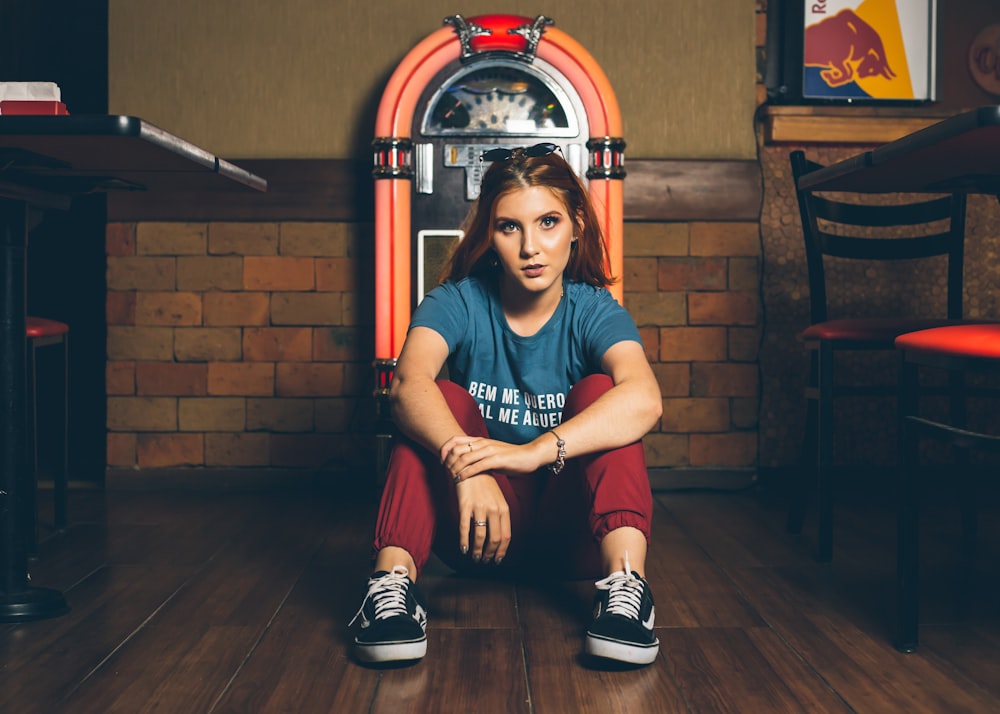 sitting woman in gray t-shirt in front of jukebox