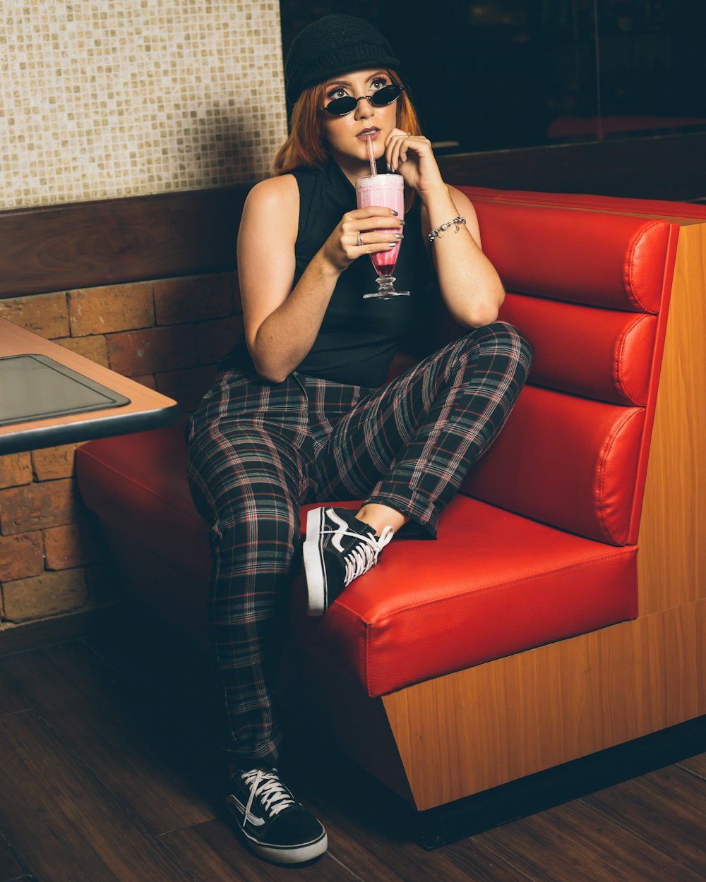 selective focus photography of sitting woman sipping drink