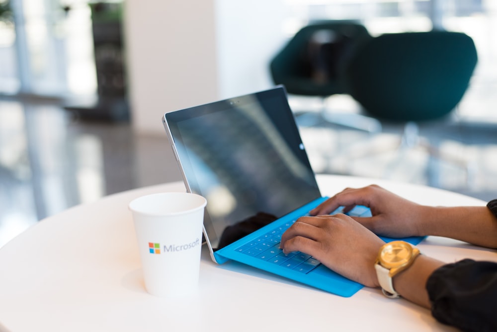 personne utilisant une Surface Microsoft bleue