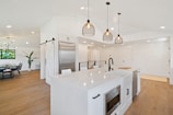 Virtual walkthrough snapshot of an open-concept kitchen with island and pendant lights.