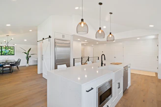 A bright, modern kitchen featuring sleek cabinetry and a spacious island with pendant lighting.