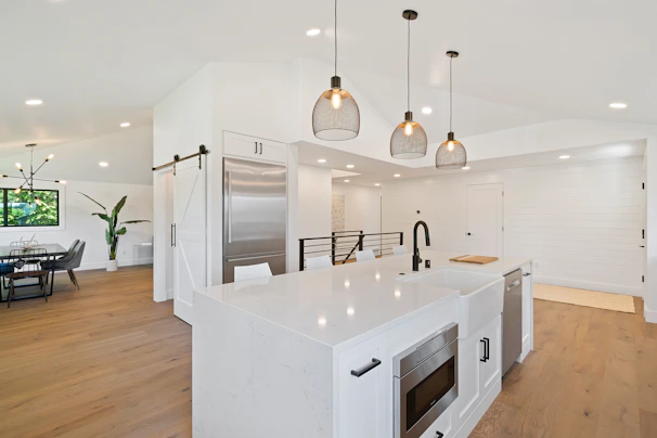 Modern kitchen featuring stainless steel appliances and a spacious island with pendant lighting