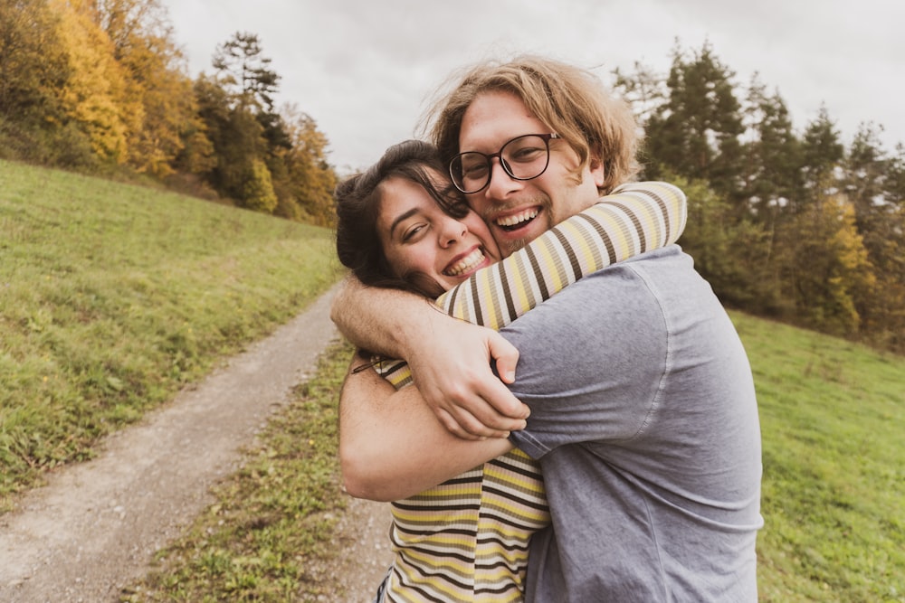 man and woman hugging near trees