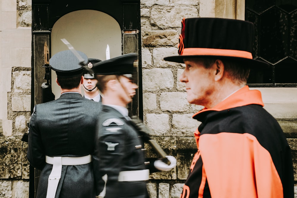 man walking beside two men wearing black officers uniform