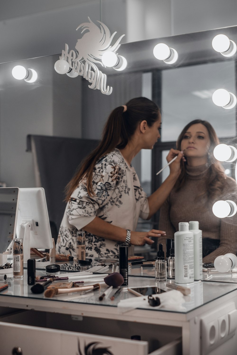 woman doging make up facing mirror