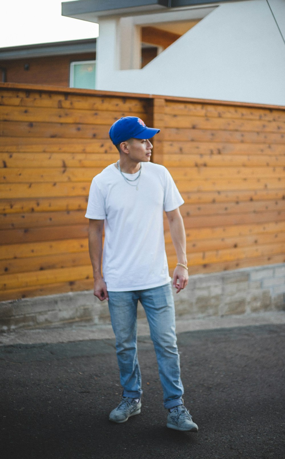Man in white crew neck t-shirt and blue denim jeans standing on gray  concrete floor photo – Free Brown Image on Unsplash
